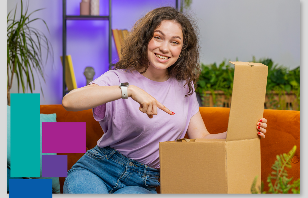 Image shows a woman in a purple t-shirt, excitedly pointing to a parcel which she is unboxing for Macfarlane Packaging's 2024 unboxing survey